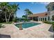 Inviting backyard pool area with tiled patio, tropical landscaping, and comfortable lounge chairs at 550 Dove Pointe, Osprey, FL 34229