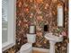 Charming powder room with floral wallpaper, pedestal sink, ornate mirror, and elegant fixtures at 550 Dove Pointe, Osprey, FL 34229