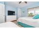 Bright bedroom featuring two beds, cool color palette, a ceiling fan and a dresser with a TV for relaxation and comfort at 6005 N Beach Rd # 16, Englewood, FL 34223
