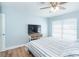 A comfy bedroom featuring a ceiling fan, TV and a large window with blinds letting natural light into the room at 6005 N Beach Rd # 16, Englewood, FL 34223