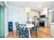 Modern dining area featuring a white table, blue chairs, and bright pendant lighting at 6005 N Beach Rd # 16, Englewood, FL 34223