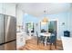 Dining area featuring a white table, blue chairs, and stainless steel kitchen appliances at 6005 N Beach Rd # 16, Englewood, FL 34223
