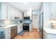 Modern kitchen with sleek white cabinets, stainless steel appliances, and stylish backsplash at 6005 N Beach Rd # 16, Englewood, FL 34223