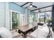 Inviting screened porch features a dining table, comfortable seating, ceiling fans and access to interior spaces at 6005 N Beach Rd # 16, Englewood, FL 34223