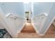 Bright wooden staircase with white railing leads to a doorway, creating an inviting transition between levels in the home at 6005 N Beach Rd # 16, Englewood, FL 34223