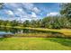 Lush backyard featuring a tranquil lake view and well-maintained lawn at 6610 Rosy Barb Ct, Lakewood Ranch, FL 34202