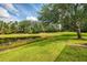 Picturesque backyard featuring a serene pond, lush greenery, and mature trees, creating a peaceful setting at 6610 Rosy Barb Ct, Lakewood Ranch, FL 34202
