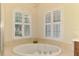 Close-up of a bathtub featuring arch-topped shuttered windows and decorative tile at 6610 Rosy Barb Ct, Lakewood Ranch, FL 34202