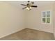 Neutral carpeted bedroom featuring a ceiling fan, plantation shutters, and ample space at 6610 Rosy Barb Ct, Lakewood Ranch, FL 34202
