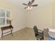 Carpeted bedroom with plantation shutters, ceiling fan, and a desk area with an office chair at 6610 Rosy Barb Ct, Lakewood Ranch, FL 34202