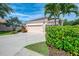 Home exterior featuring a long driveway, mature landscaping, and an attached three-car garage at 6610 Rosy Barb Ct, Lakewood Ranch, FL 34202
