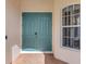 Close-up of the teal double front door with sidelight window, offering a charming welcome at 6610 Rosy Barb Ct, Lakewood Ranch, FL 34202