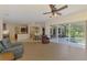 Bright living room with tile floors and glass sliding doors that open to a screened-in patio with pond view at 6610 Rosy Barb Ct, Lakewood Ranch, FL 34202