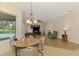 Open-concept living and dining area with hardwood floors, pool view, and modern furnishings at 6610 Rosy Barb Ct, Lakewood Ranch, FL 34202