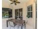 Covered patio featuring an outdoor dining table with chairs, ceiling fan, and a view of the pool at 6610 Rosy Barb Ct, Lakewood Ranch, FL 34202