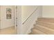 Carpeted staircase with a white handrail and view to the outside with shuttered window at 6610 Rosy Barb Ct, Lakewood Ranch, FL 34202