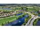 Expansive aerial view of a golf course community, highlighting water features, the green, and lush scenery at 7634 Windy Hill Cv, Bradenton, FL 34202