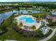 Aerial view of the resort-style community pool, clubhouse, and lake at 7634 Windy Hill Cv, Bradenton, FL 34202