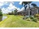 Spacious backyard with screened lanai, and lush landscaping bordering the water at 7634 Windy Hill Cv, Bradenton, FL 34202