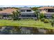Aerial shot of backyard with screened pool, lush landscaping, and scenic water view at 7634 Windy Hill Cv, Bradenton, FL 34202