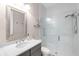 Modern bathroom featuring a glass-enclosed shower, granite countertop, and a large mirror at 7634 Windy Hill Cv, Bradenton, FL 34202