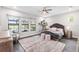 Bright bedroom features elegant decor, a tufted headboard, and windows overlooking the pool and yard at 7634 Windy Hill Cv, Bradenton, FL 34202