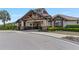 Clubhouse exterior with stone accents, manicured landscaping, and covered entrance at 7634 Windy Hill Cv, Bradenton, FL 34202