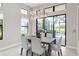 Dining room features a modern chandelier, neutral color palette, and views of the screened in lanai at 7634 Windy Hill Cv, Bradenton, FL 34202