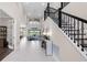 Grand foyer with high ceilings, tile floors, elegant staircase, and open floor plan at 7634 Windy Hill Cv, Bradenton, FL 34202