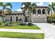 Elegant home featuring a tile roof, arched entry, two car garage, and lush landscaping at 7634 Windy Hill Cv, Bradenton, FL 34202