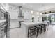 Well-lit kitchen boasting white cabinets, stainless appliances, tile backsplash, and a center island with seating at 7634 Windy Hill Cv, Bradenton, FL 34202