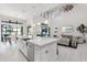 Open-concept kitchen island with stainless steel appliances, white cabinets, and views into the living area at 7634 Windy Hill Cv, Bradenton, FL 34202