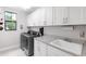 Laundry room features a front load washer and dryer set, storage cabinets, and a sink at 7634 Windy Hill Cv, Bradenton, FL 34202