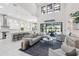 Bright living room featuring high ceilings, tile floors, and modern furnishings flowing into the kitchen at 7634 Windy Hill Cv, Bradenton, FL 34202