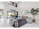 Open-concept living area with soaring ceilings, modern decor, and seamless access to outdoor living at 7634 Windy Hill Cv, Bradenton, FL 34202