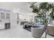 Open living area with tall windows, tile flooring, and views into the kitchen and lanai at 7634 Windy Hill Cv, Bradenton, FL 34202