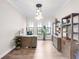 Home office with modern desk, built-in storage, a decorative lighting fixture, and hardwood floors at 7634 Windy Hill Cv, Bradenton, FL 34202