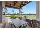 Beautiful outdoor kitchen with a built-in grill, dining area, and serene views of the lake at 7634 Windy Hill Cv, Bradenton, FL 34202