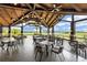 Covered patio showcasing an elegant chandelier, tiled floors, and golf course views at 7634 Windy Hill Cv, Bradenton, FL 34202