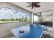 Patio with ping pong table overlooking a lake and a golf course with an open window view to a living room at 7634 Windy Hill Cv, Bradenton, FL 34202