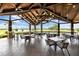 Covered patio showcasing an elegant chandelier, tiled floors, and golf course views at 7634 Windy Hill Cv, Bradenton, FL 34202