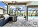 Outdoor kitchen and covered patio offering stunning views of the pool, golf course, and beautiful landscaping at 7634 Windy Hill Cv, Bradenton, FL 34202