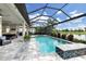 Inviting pool area with a spa, lush landscaping, and a covered patio, offering the ultimate in outdoor living at 7634 Windy Hill Cv, Bradenton, FL 34202
