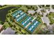 Aerial view of well-maintained tennis courts surrounded by lush greenery and manicured landscaping at 7634 Windy Hill Cv, Bradenton, FL 34202