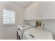 Well-lit laundry area with cabinets, a window, and appliances at 803 Montrose Dr # 201, Venice, FL 34293