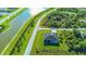 Birds eye view of a home showcasing its location near a lake, road, and lush greenery at 8045 Bosco Rd, Port Charlotte, FL 33981