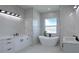 Modern bathroom features white marble, a free-standing tub, and dual vanities with black fixtures at 8045 Bosco Rd, Port Charlotte, FL 33981