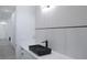 Stylish bathroom featuring a modern rectangular black marble sink with sleek fixtures, complemented by a floating white vanity at 8045 Bosco Rd, Port Charlotte, FL 33981