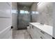 Modern bathroom showcasing dual shower heads, gray marble style tile, and a sleek white vanity with elegant fixtures at 8045 Bosco Rd, Port Charlotte, FL 33981