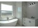 Bright bathroom with a freestanding tub next to a window and a vanity with marble surround at 8045 Bosco Rd, Port Charlotte, FL 33981
